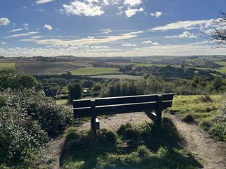 An image of a bench against a landscape of hills taken on an iPhone 13