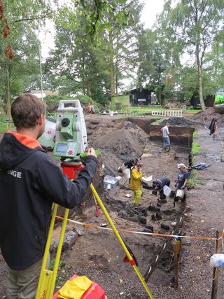 Surveying the excavation, bone desecration