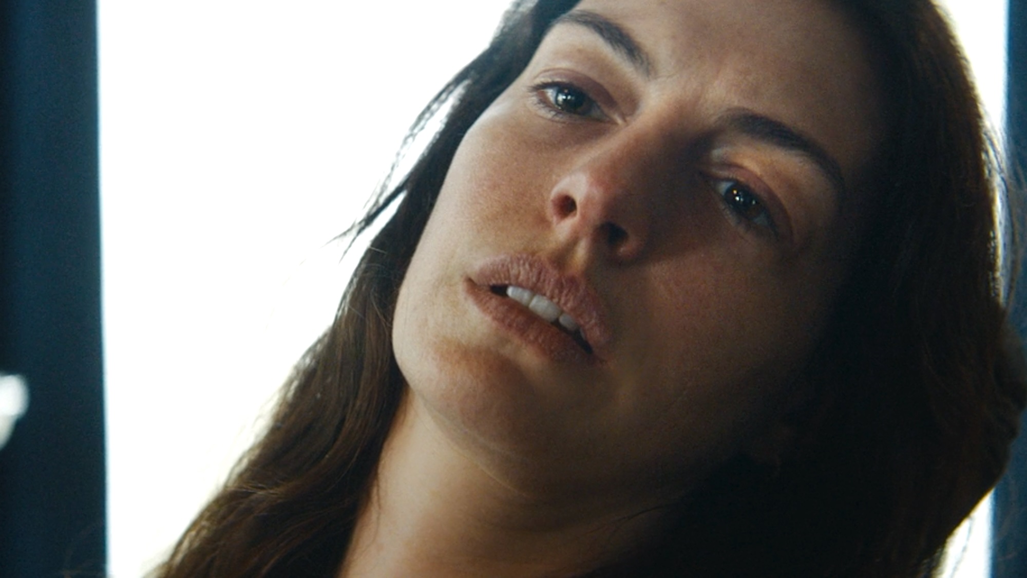 Anne Hathaway looking ill and staring out at nothing in Verity