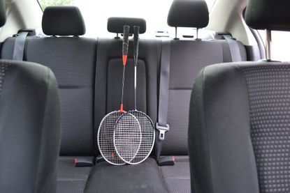 A pair of badminton racquets on the back seat of a family car.