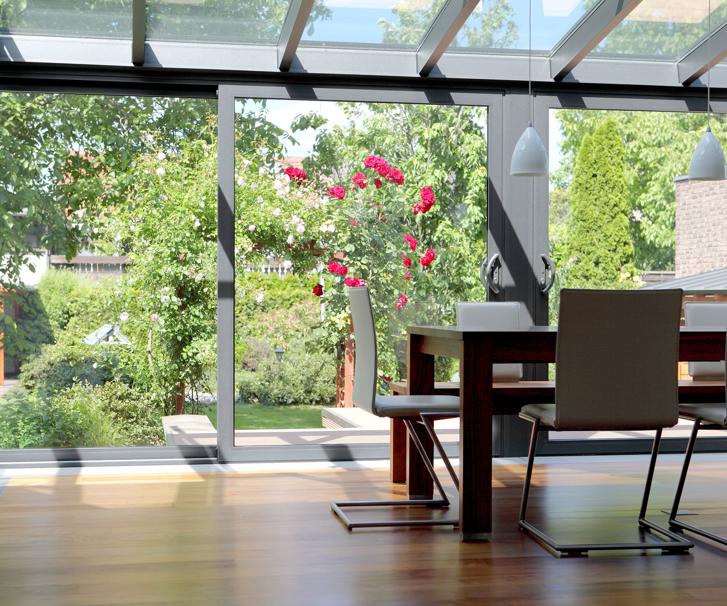 glass dining room extension with wooden flooring and sliding doors