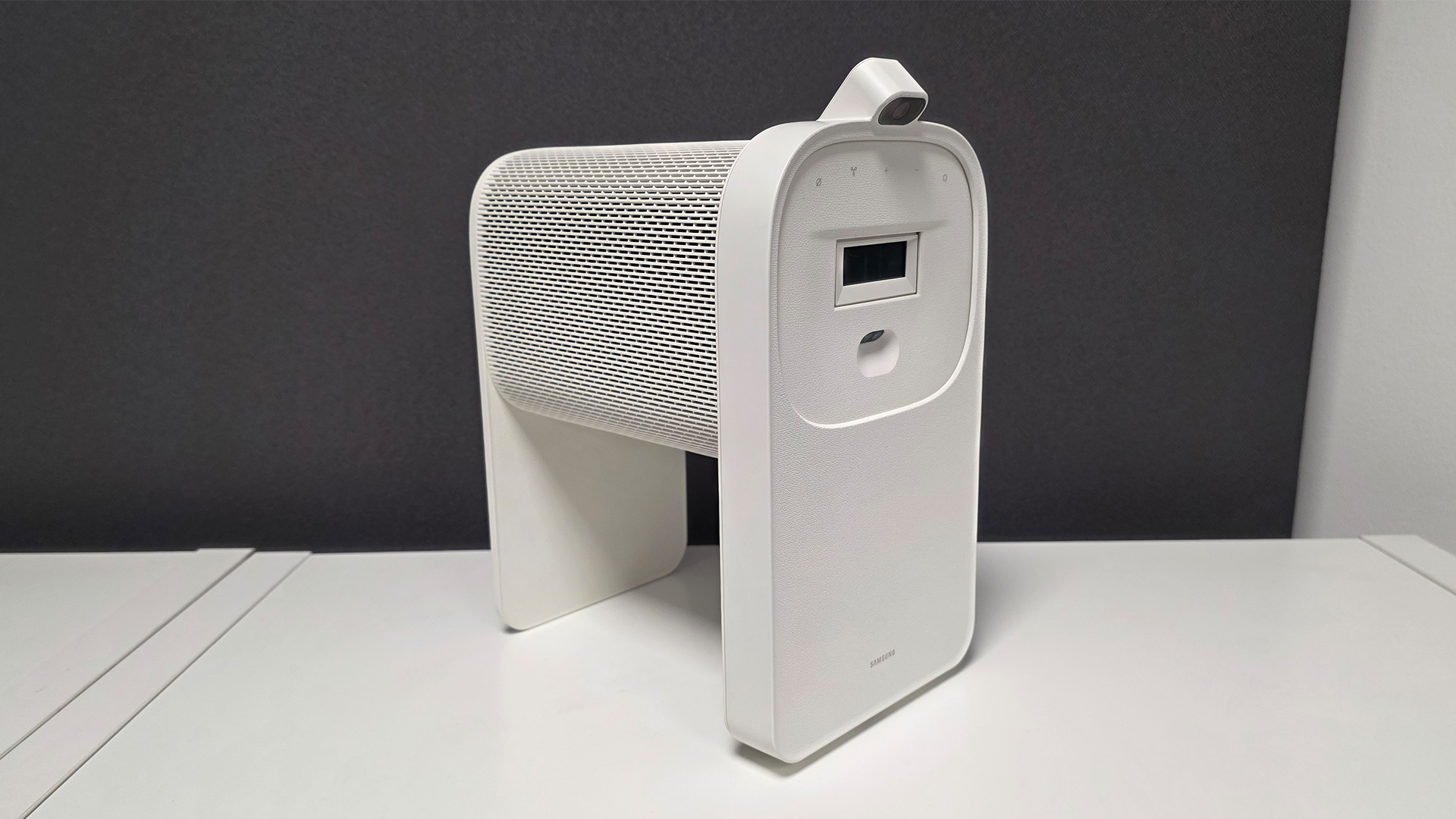 Samsung The Premiere 5 ultra short throw projector on white surface against dark background