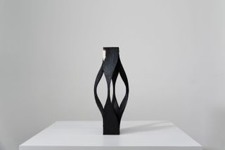 Black colour sculpture on table.
