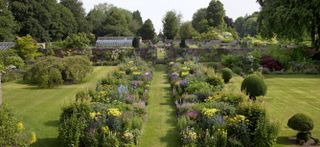 Looking down the mirrored herbaceous border in the gardens at Bramdean House.