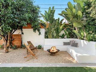 small backyard with fire pit furniture and tropical planting