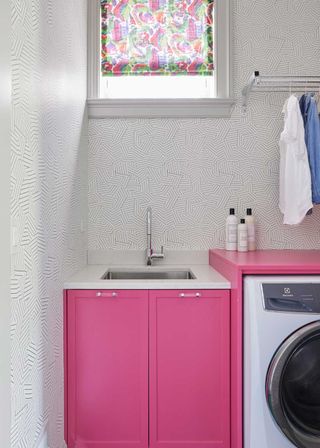 hot pink cabinets in a utility room with funky white wallpaper