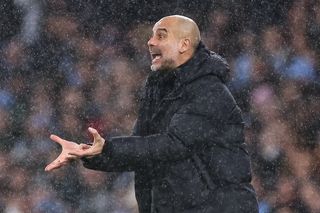 Manchester City manager Pep Guardiola pictured in rainy conditions during an FA Cup tie against Burnley in March 2023.