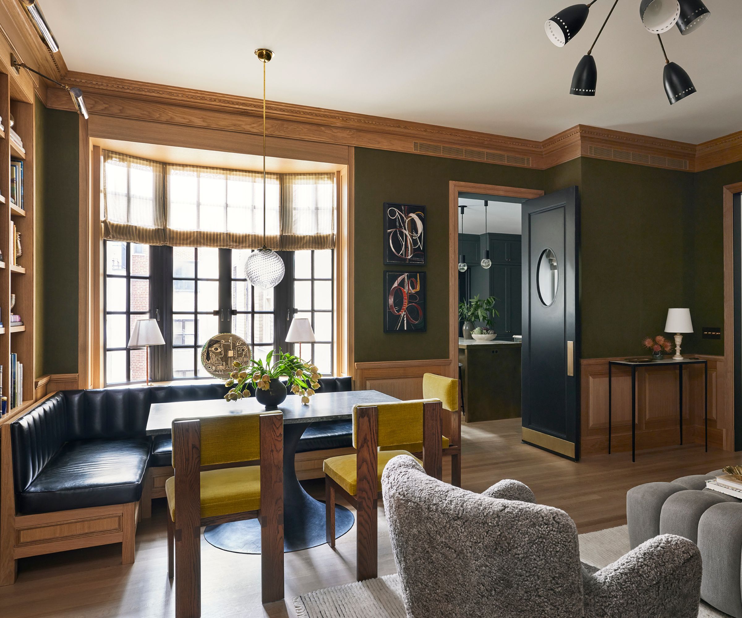 A oak-detailed family room with green linen wallcoverings
