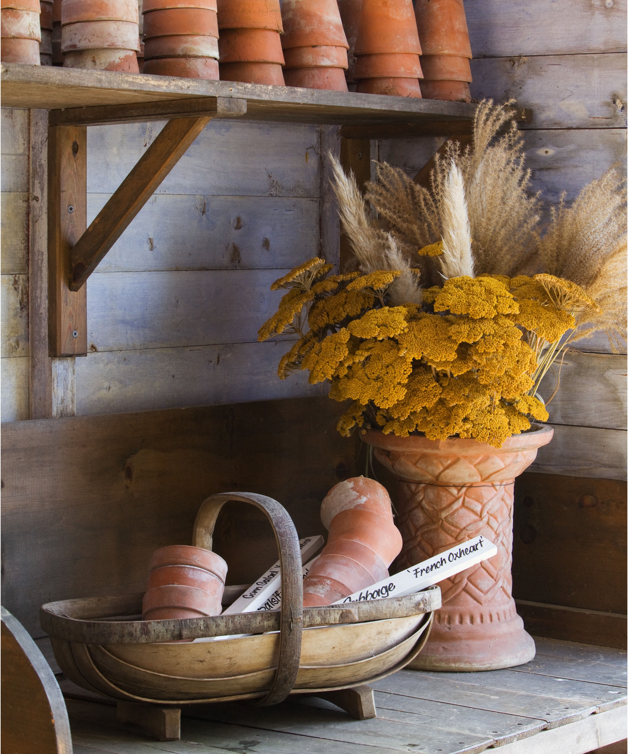 Potting shed bench with terracotta pots and a floral arrangement
