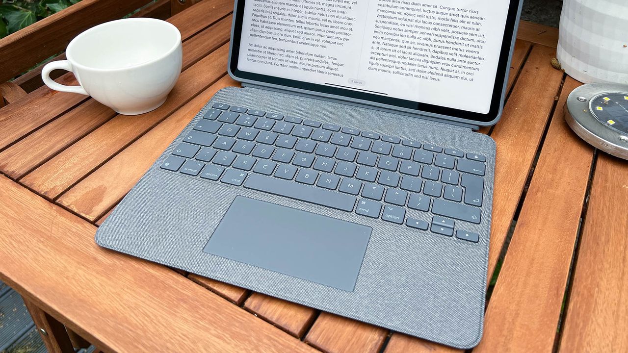 A photograph of the 12.9in Apple iPad Pro on a garden table with a keyboard case