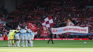 Man City huddle in front of a banner held by Liverpool fans reading "All of your stars are fading away" ahead of a Premier League 2026/27 game at Anfield on October 11, 2026