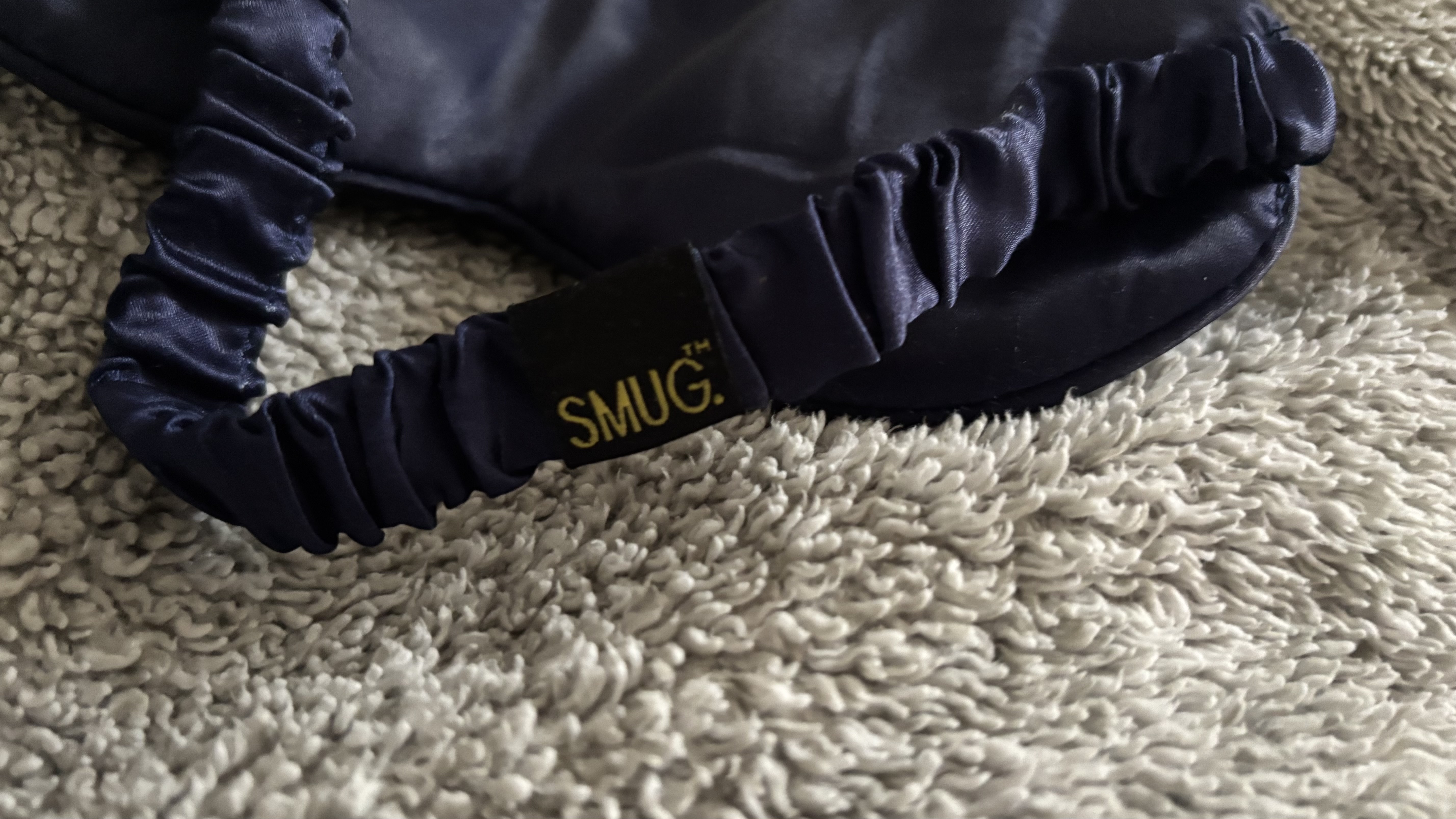 The elasticated strap of the SMUG Satin Sleep Mask in navy.