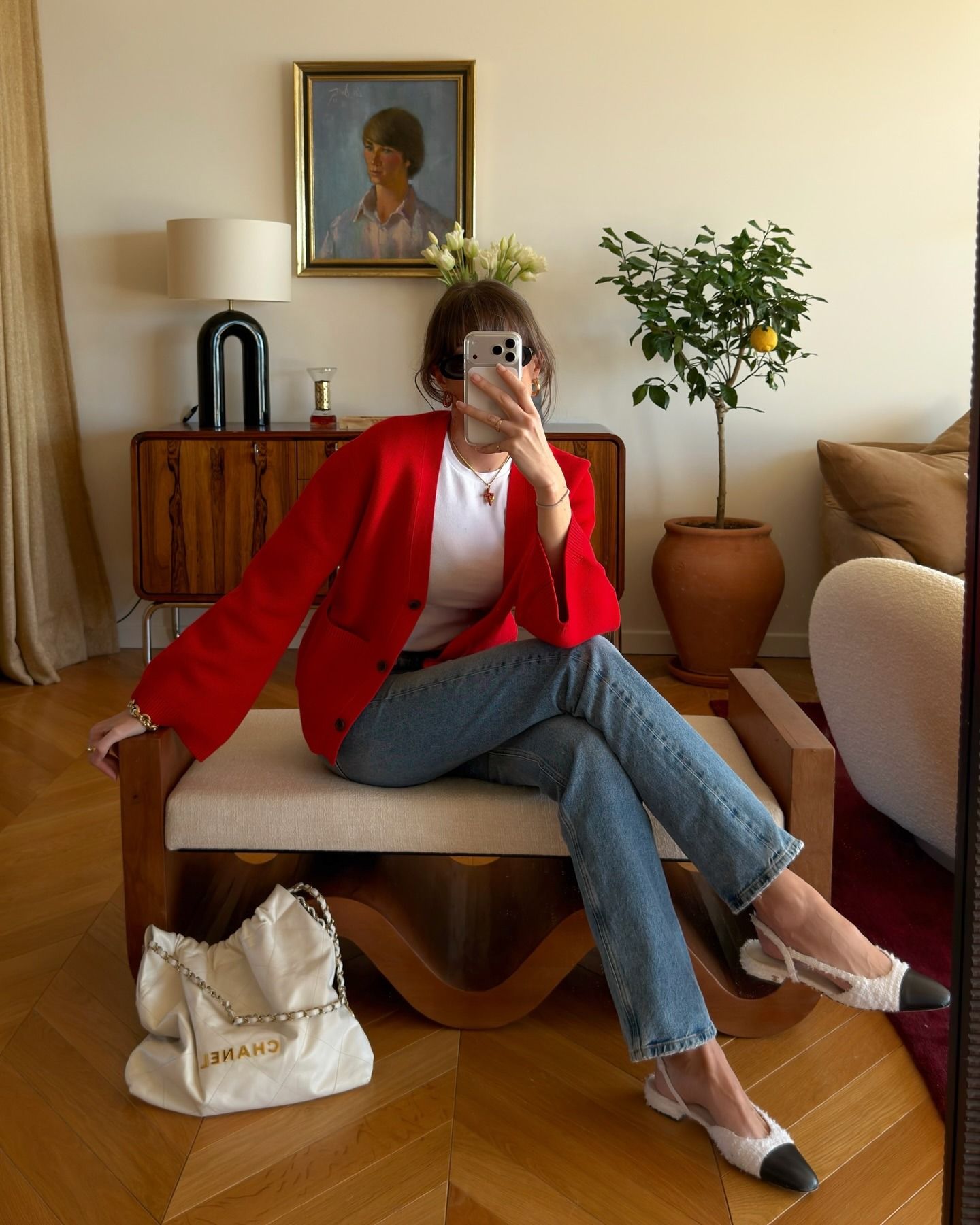 @juliesfi wearing a red cardigan, white crewneck, blue jeans, Chanel bag, and cap-toe slingback heels