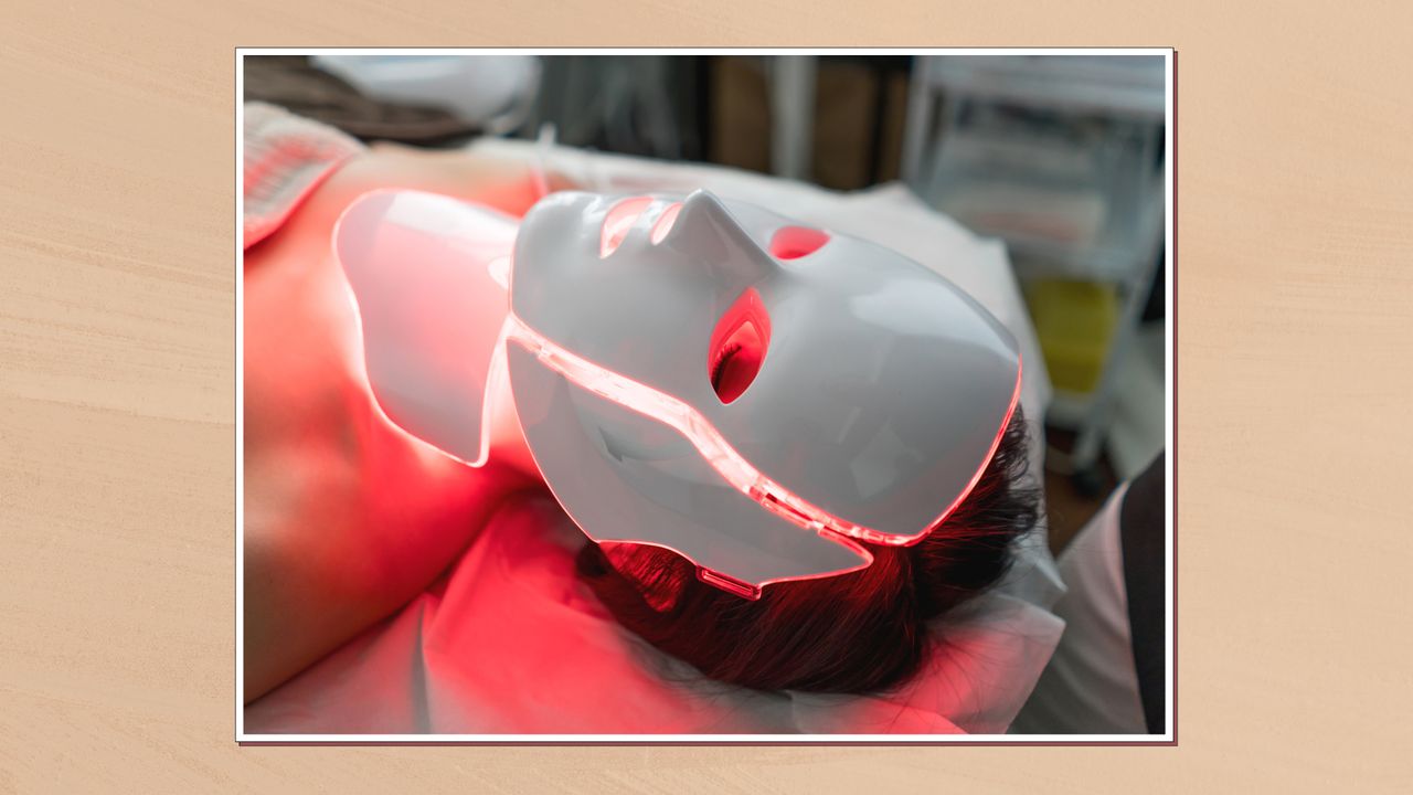 Image of woman laying on treatment bed wearing a red light therapy mask, in a white frame against an ochre watercolour-style background