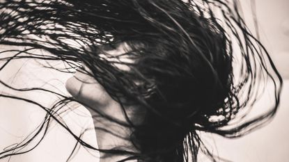 Artful image of woman with wet hair to depict story for is it okay to sleep with wet hair