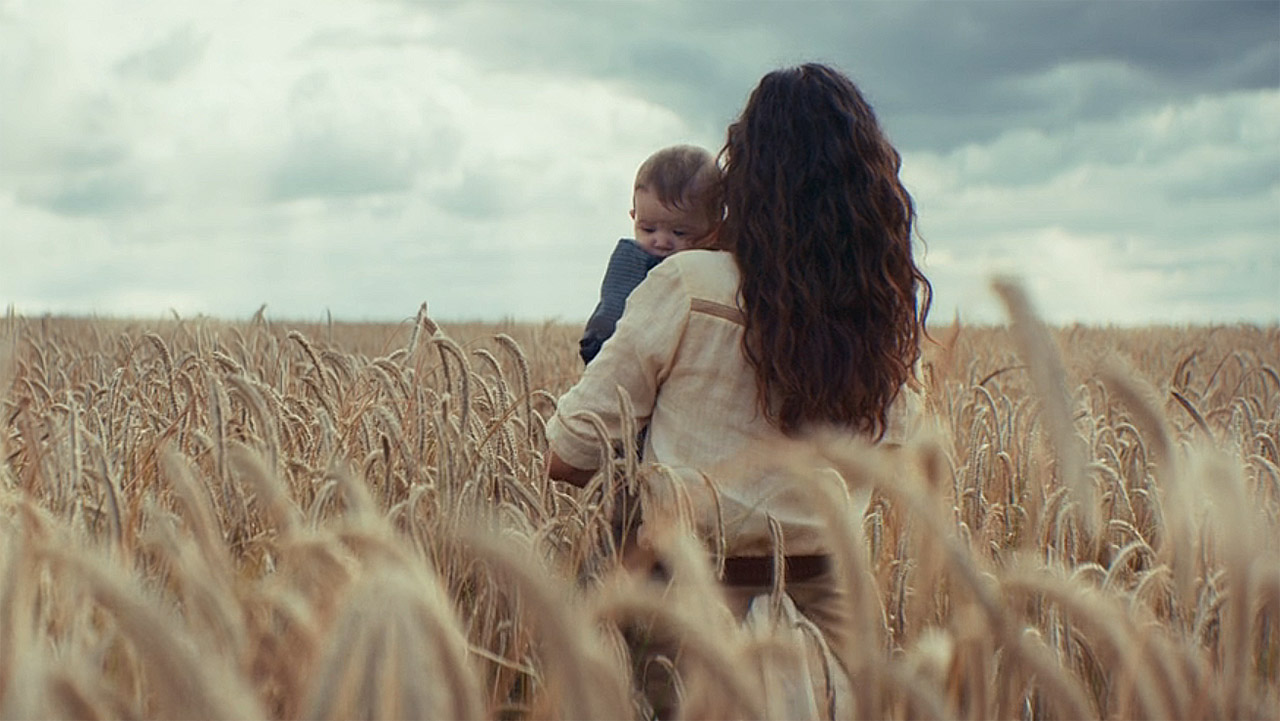 Bix looking at sun pouring through the clouds as she holds her baby in Andor's season 2 finale