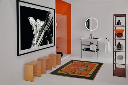 A modern bathroom with orange accents and a large sink on a black frame