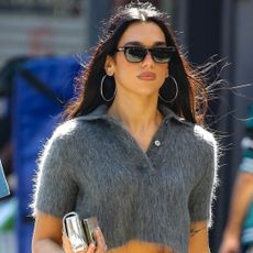 Dua Lipa was spotted in NYC wearing an orange Gucci skirt and a fur polo shirt