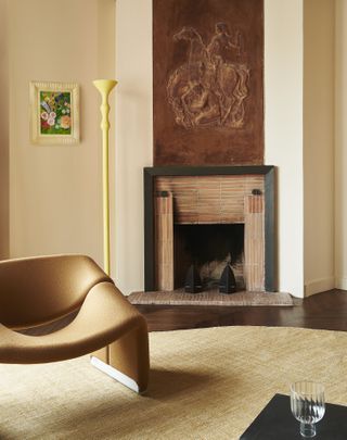 A living room with cream-pink walls, and a brown armchair