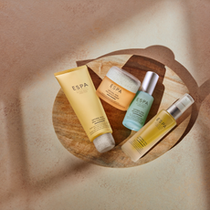 ESPA skincare products on a round wooden board