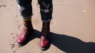 A person wearing doc martens on the beach