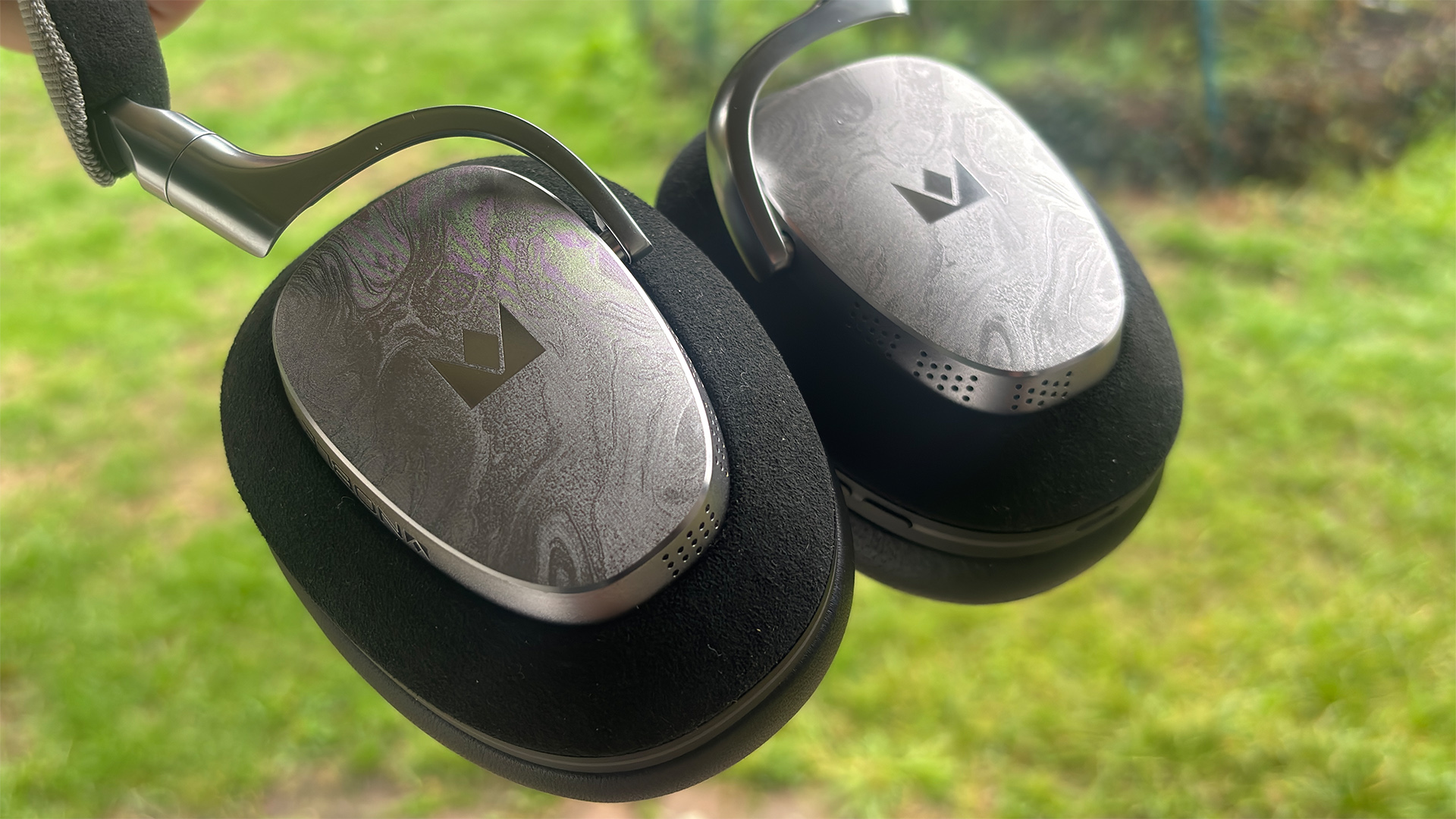Noble Fokus Artemis over-ear headphones held above lawn