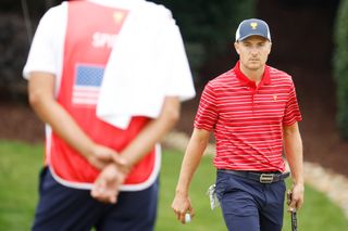 Jordan Spieth walks off the green whilst staring at his caddie