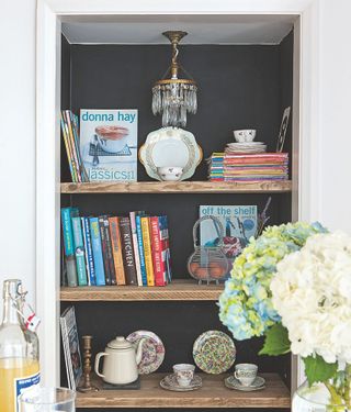 bookshelf with books teapot cup and saucer