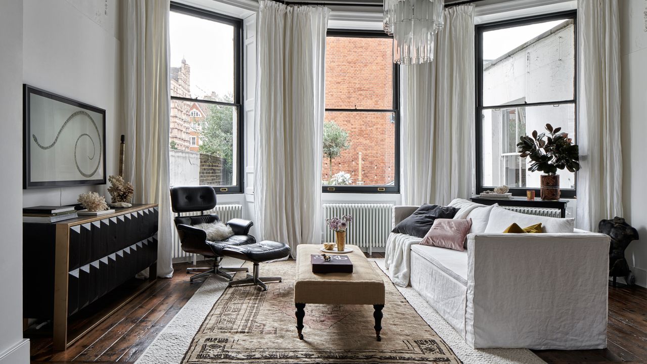 White boho-style living room with white sofa and eames chair