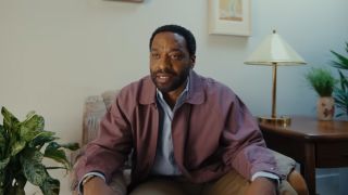 Chiwetel Ejiofor looking frustrated in a purple-ish jacket in Backrooms
