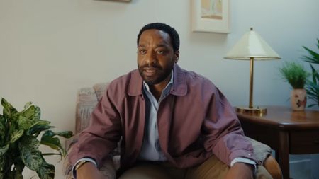 Chiwetel Ejiofor looking frustrated in a purple-ish jacket in Backrooms