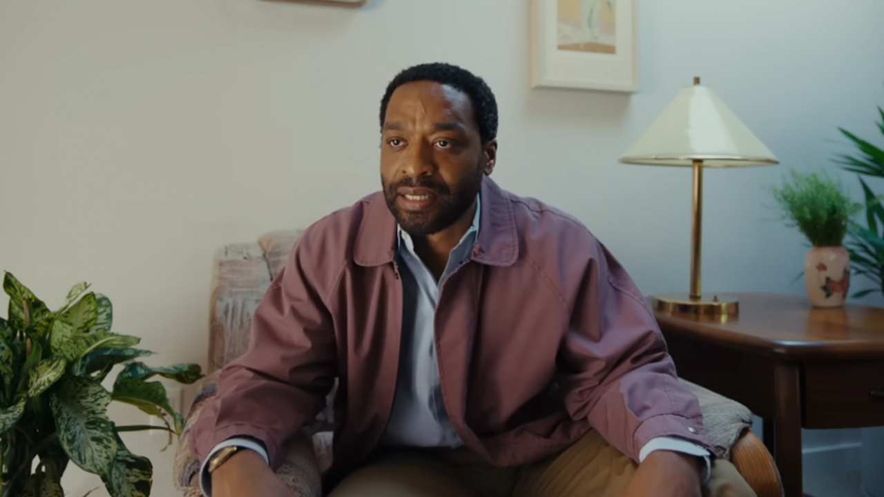 Chiwetel Ejiofor looking frustrated in a purple-ish jacket in Backrooms