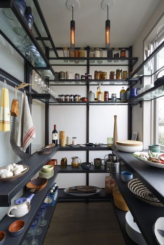 Kitchen pantry with open shelving and hanging racks