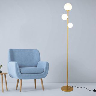A big Bang 3 Globe Mid Century Modern Floor Lamp next to a blue chair