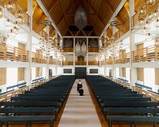 Interior of church with high wooden ceiling and chandeliers