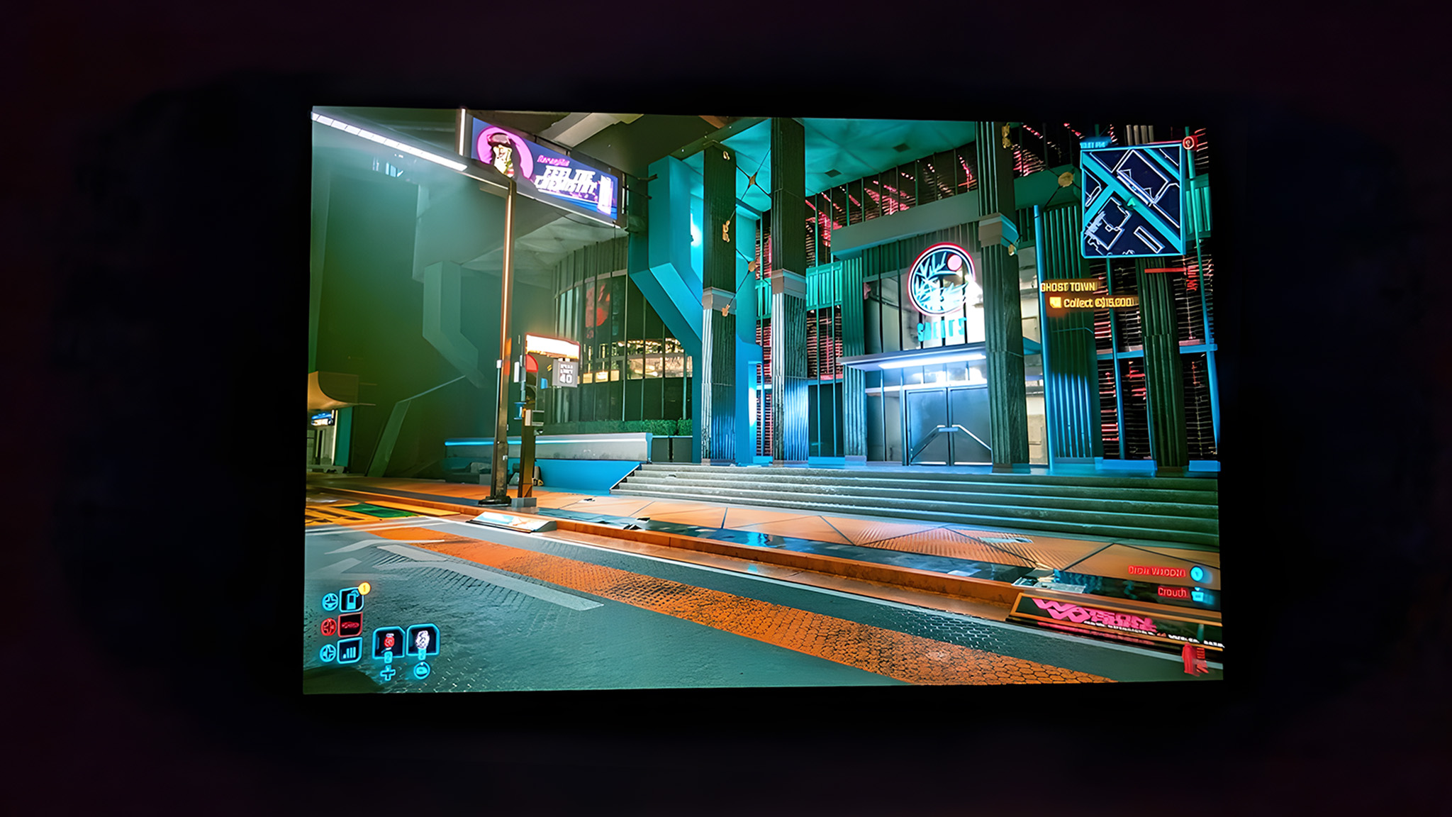 A picture taken in a dark room of the Lenovo Legion Go 2's OLED display. It's showing a vibrant scene from Cyperpunk 2077.