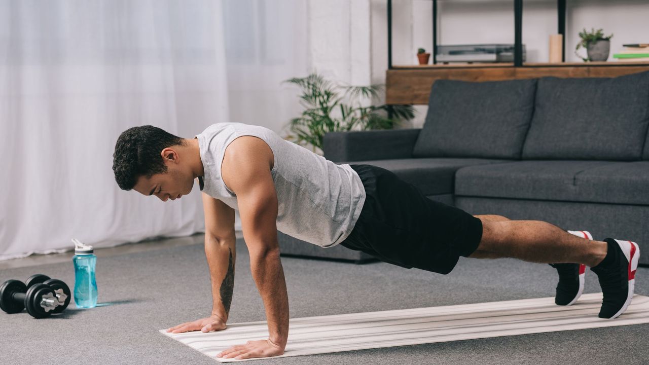 Man performing push ups in his living room