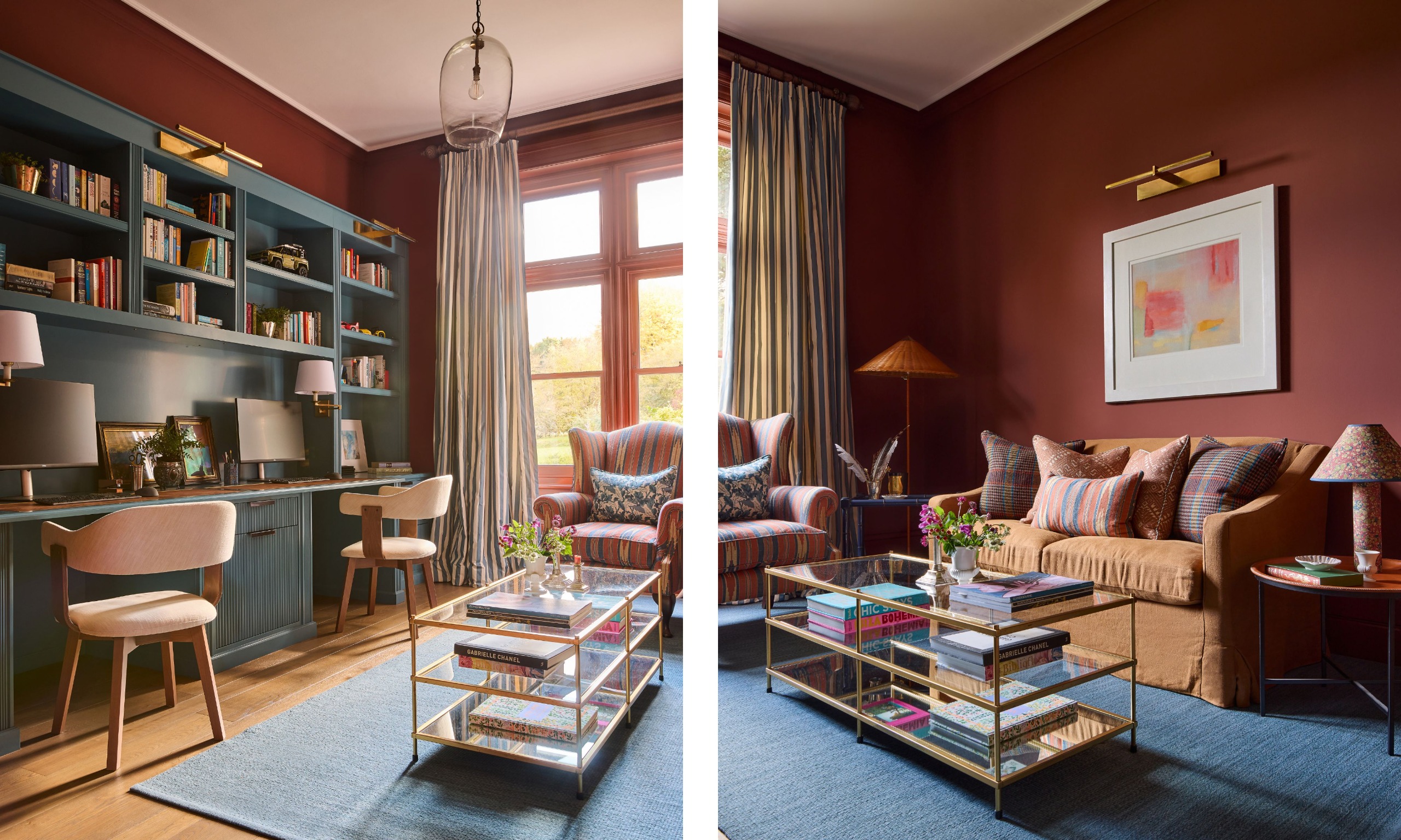 A study with dark red walls, a wall of muted blue joinery with shelving, and two desk spaces. A blue rug, a caramel sofa, a brass-and-glass coffee table, and an abstract artwork on the wall with a brass picture light.