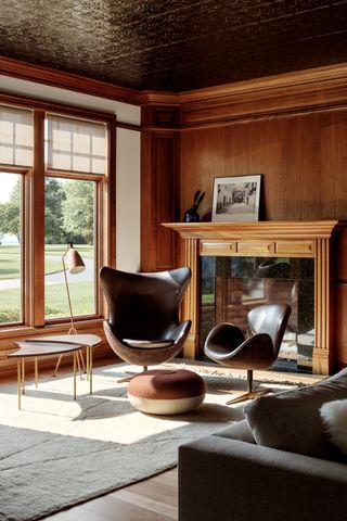 A wood clad library room with a leather chair