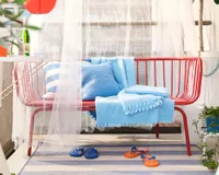 A red metal outdoor bench on an outside terrace