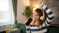 A young woman listens to music with headphones.