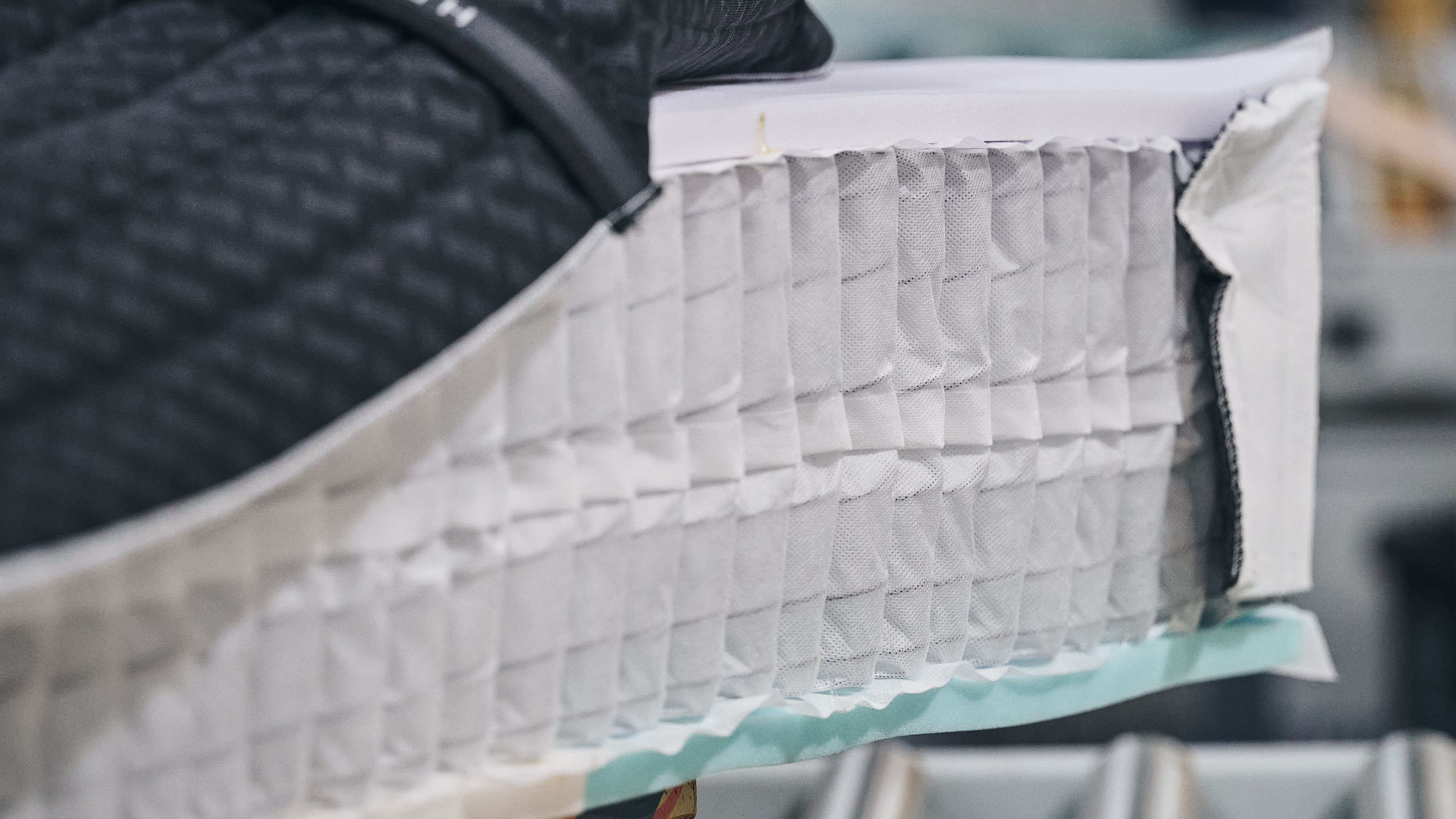 Pocketed coils inside a mattress in a factory