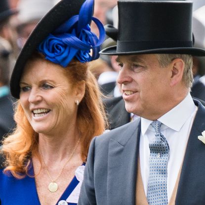 Sarah Ferguson wears a blue dress and matching hat as she attends Acot with Prince Andrew who is wearing a top hat and tails