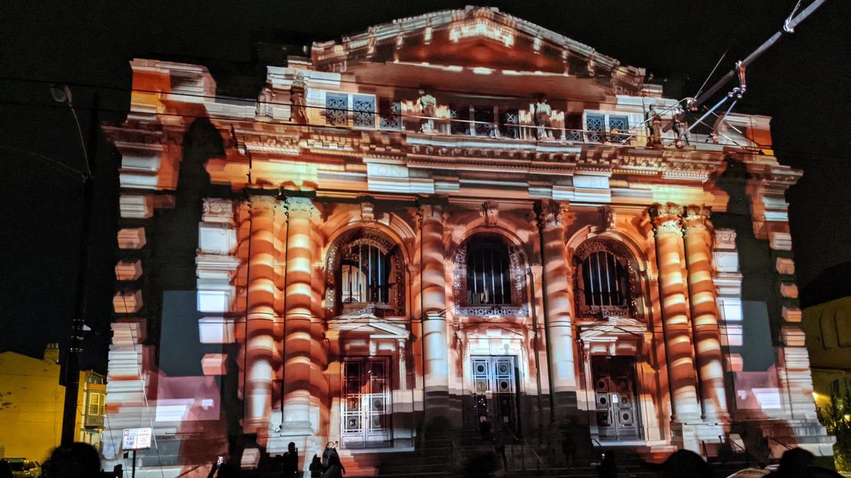 A house illuminated in multiple colors at night with projection mapping powered by Hippotizer Media Servers.