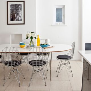 modern white dining room with metal chairs and an oval table