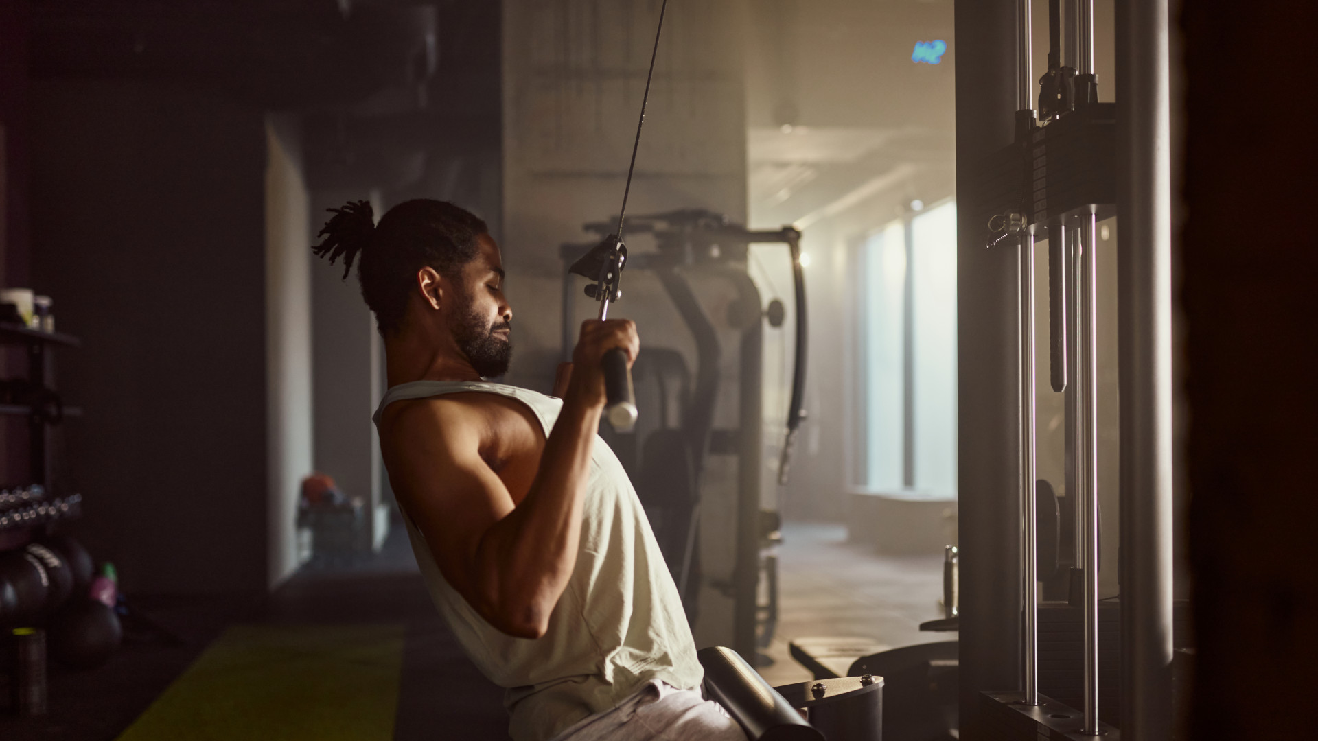 A man using the lat pull down machine at the gym