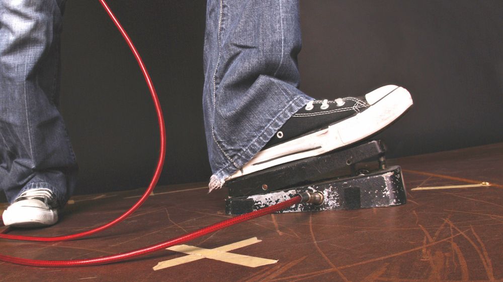 Foot resting on a wah pedal