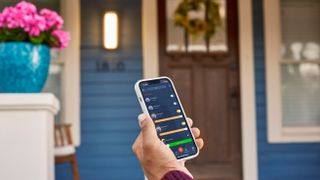 Someone using the Hubspace app in front of their home.