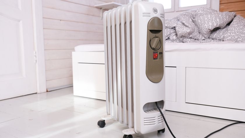 Oil filled radiator in front of a bed