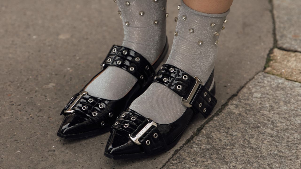 Woman wearing black slingback flats with gray socks. 